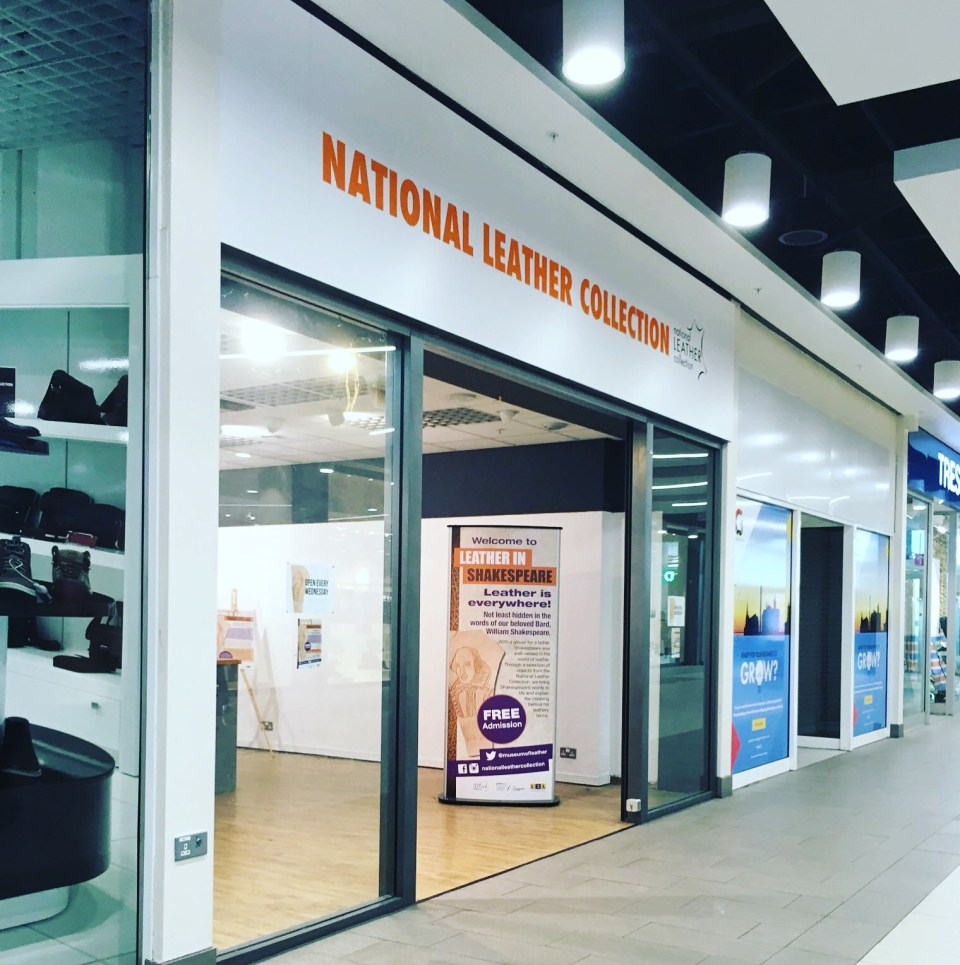 Image showing the entrance to the Museum of Leathercraft (formerly the National Leather Collection). The entrance is white with orange signage and there is an open glass door welcoming visitors to the museum.