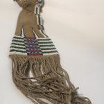 A Cheyenne pipe-bag with striped beading and tassled fringe.