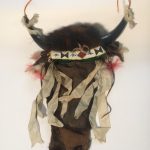 Image shows a headdress made by A. D. Burnett after the Northern Plains style. The headdress has two horns pointing upwards and beading on the front.
