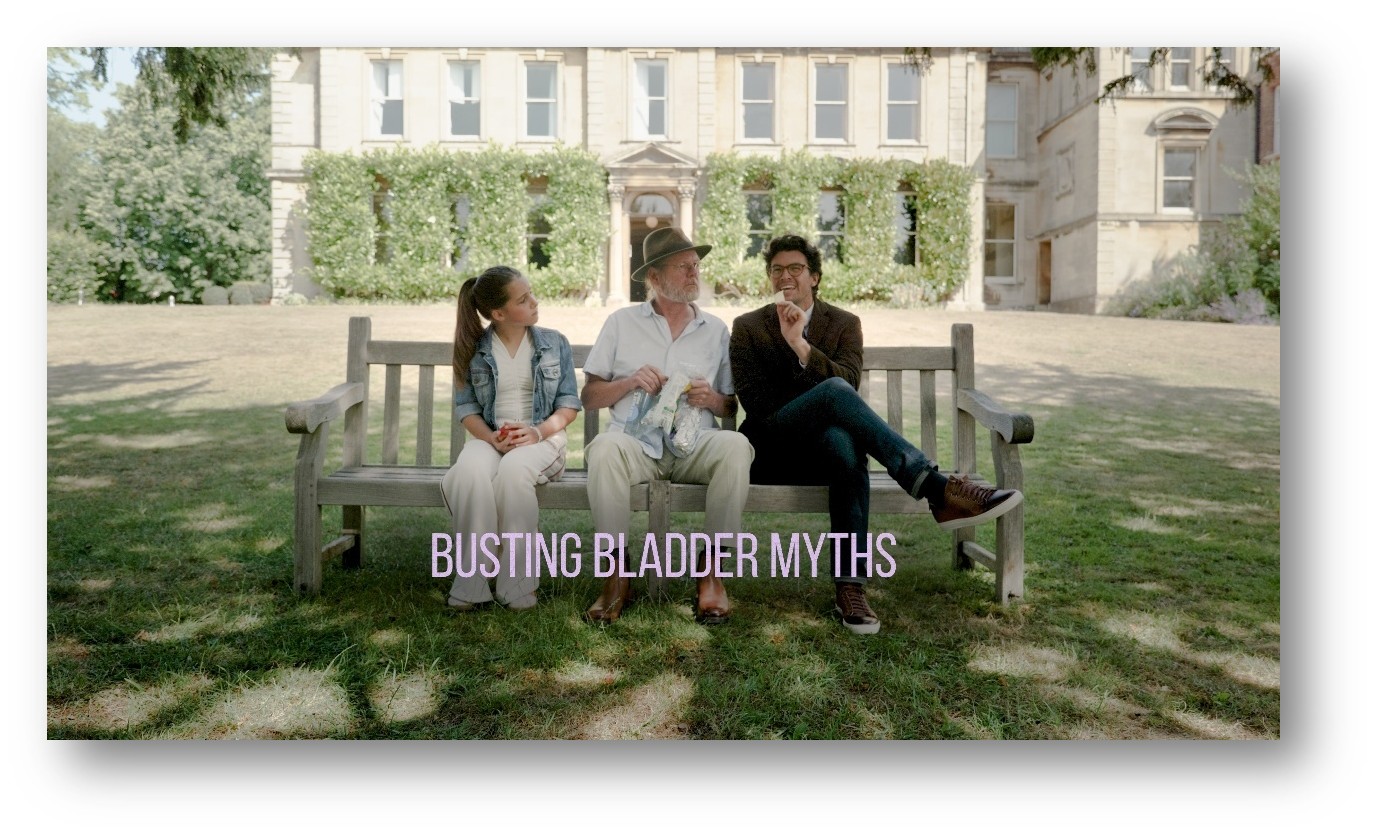 Three people sitting on a bench. The man on the far right is saying something to the other two, who are looking at him somewhat quizzically. The words 'Busting Bladder Myths' are also across the screen.