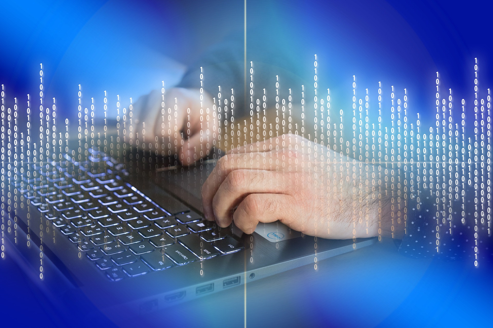 person's hands on a laptop keyboard with blue background with binary numbers