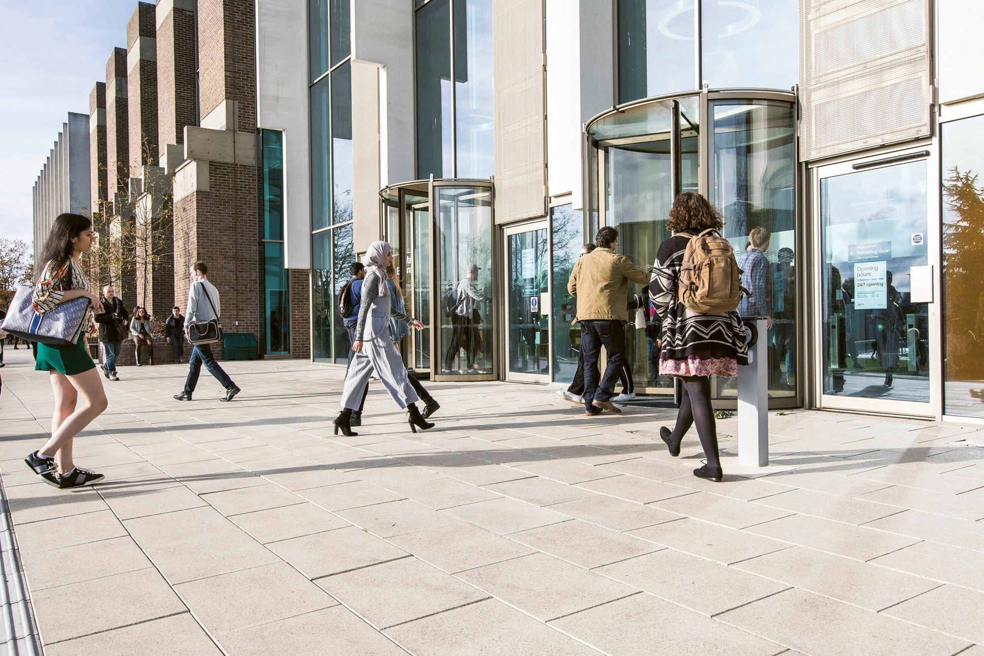 Peopling entering and exiting a building through two revolving doors