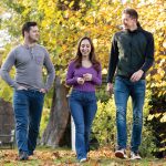 Three people walking forwards in a garden