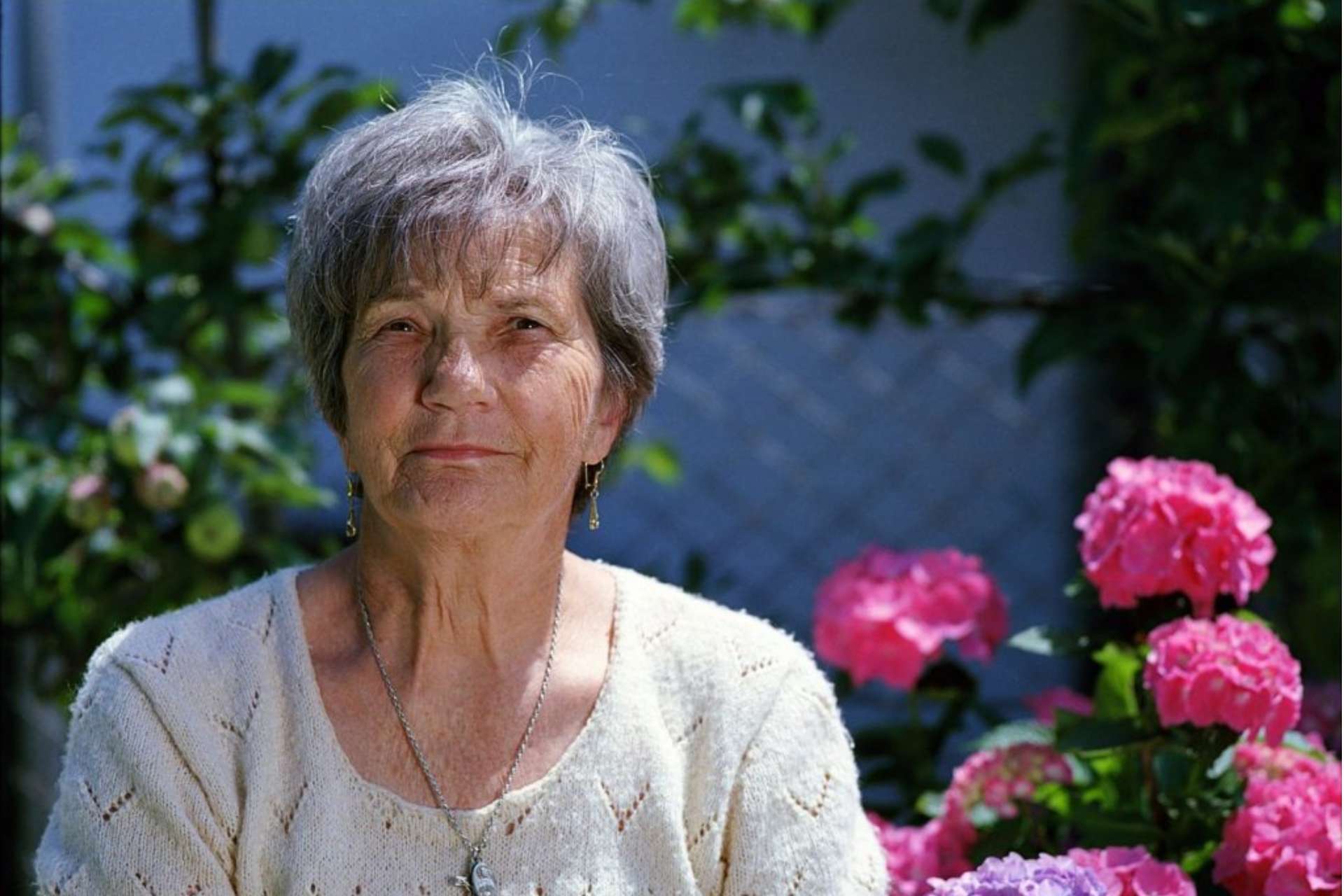 Elderly woman sitting in garden