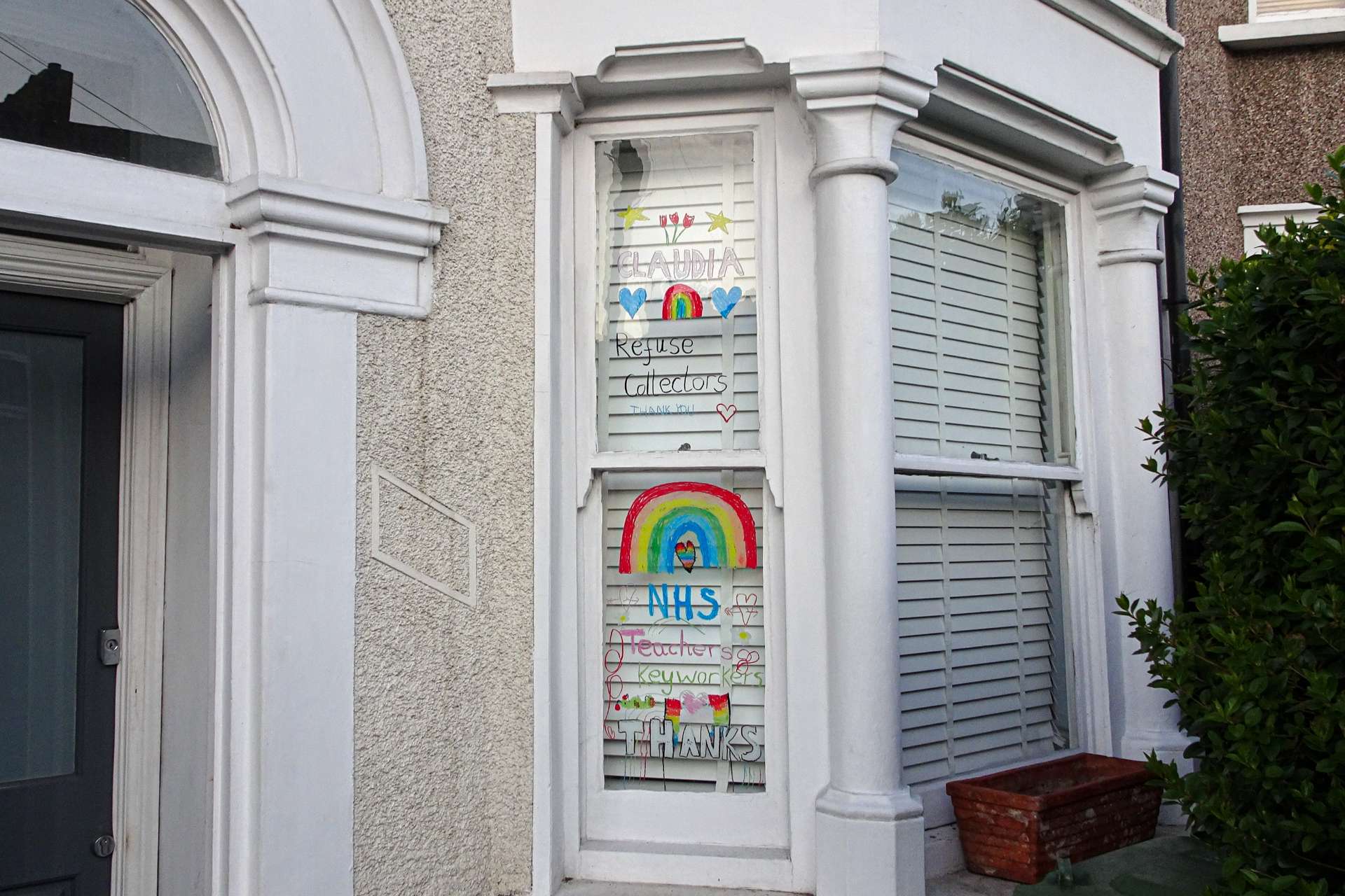 Window of house displaying pictures of rainbows and messages of thanks to keyworkers