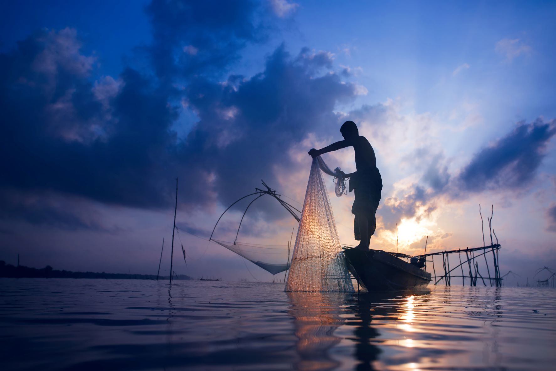 Silhouette of a fisherman on a boat